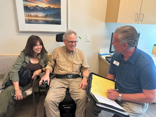 Care Coordinator Jared Nelson stands with a family at the University of Utah ALS Clinic, reflecting collaborative, compassionate support for patients and caregivers.