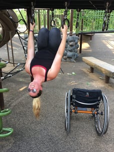 Jill hanging upside down on playground equipment
