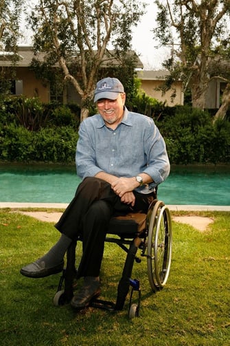 Allen Rucker in front of a pool wearing a blue shirt and hat