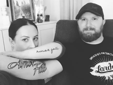 Brooke and her husband showing their "Amor Fati" tattoos