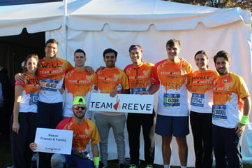 Team Reve members posing together in matching orange shirts and holding a Team Reeve sign