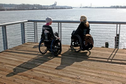 two women in wheelchairs on boardwalk