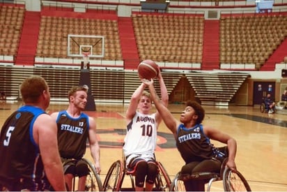 Curran playing wheelchair basketball with 3 other people.