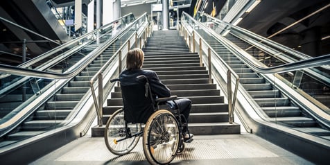 individual using a wheelchair sitting on front of stairs