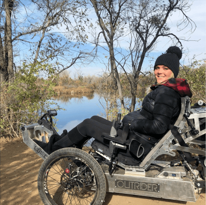 Ellie using an Outrider chair in front of a lake