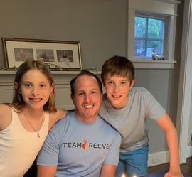 Dennis wearing a Team Reeve tshirt with his children