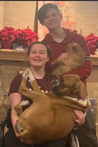 Kendra holding her dog with her older brother