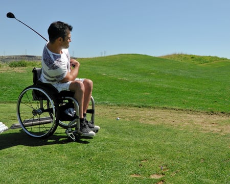 Man in wheelchair playing golf