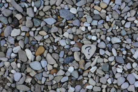 rock with question mark surrounded by other rocks