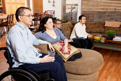 Man in wheelchair sitting with family in living room
