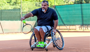 man in wheelchair playing tennis