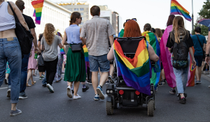 woman with a pride flag on wheelchair at pride parade