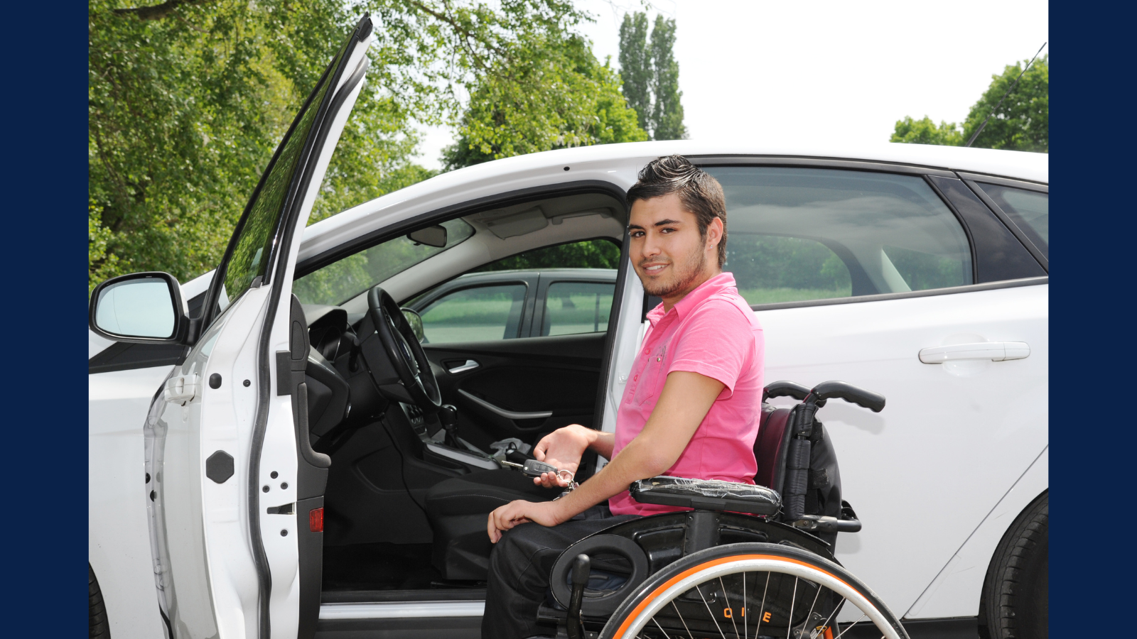 latino man in wheelchair next to car