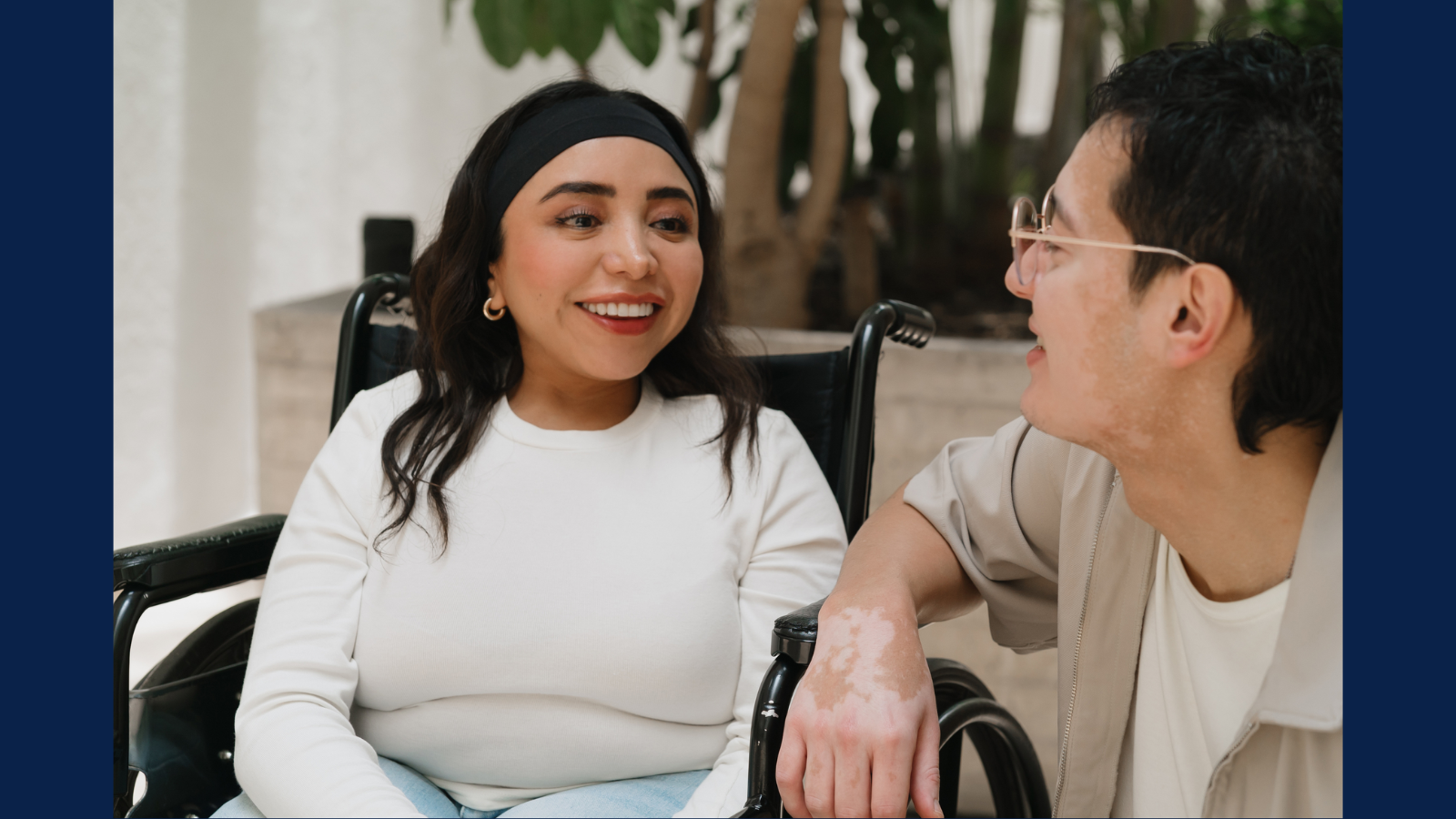 woman in wheelchair talking to man leaning on car