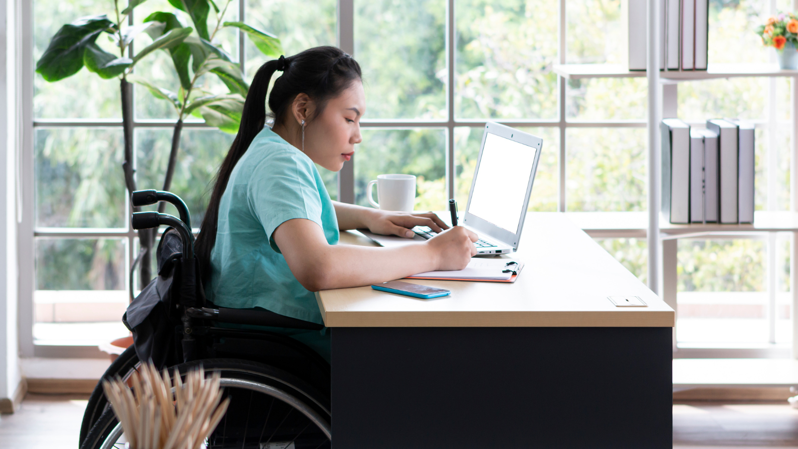 woman in wheelchair working at desk