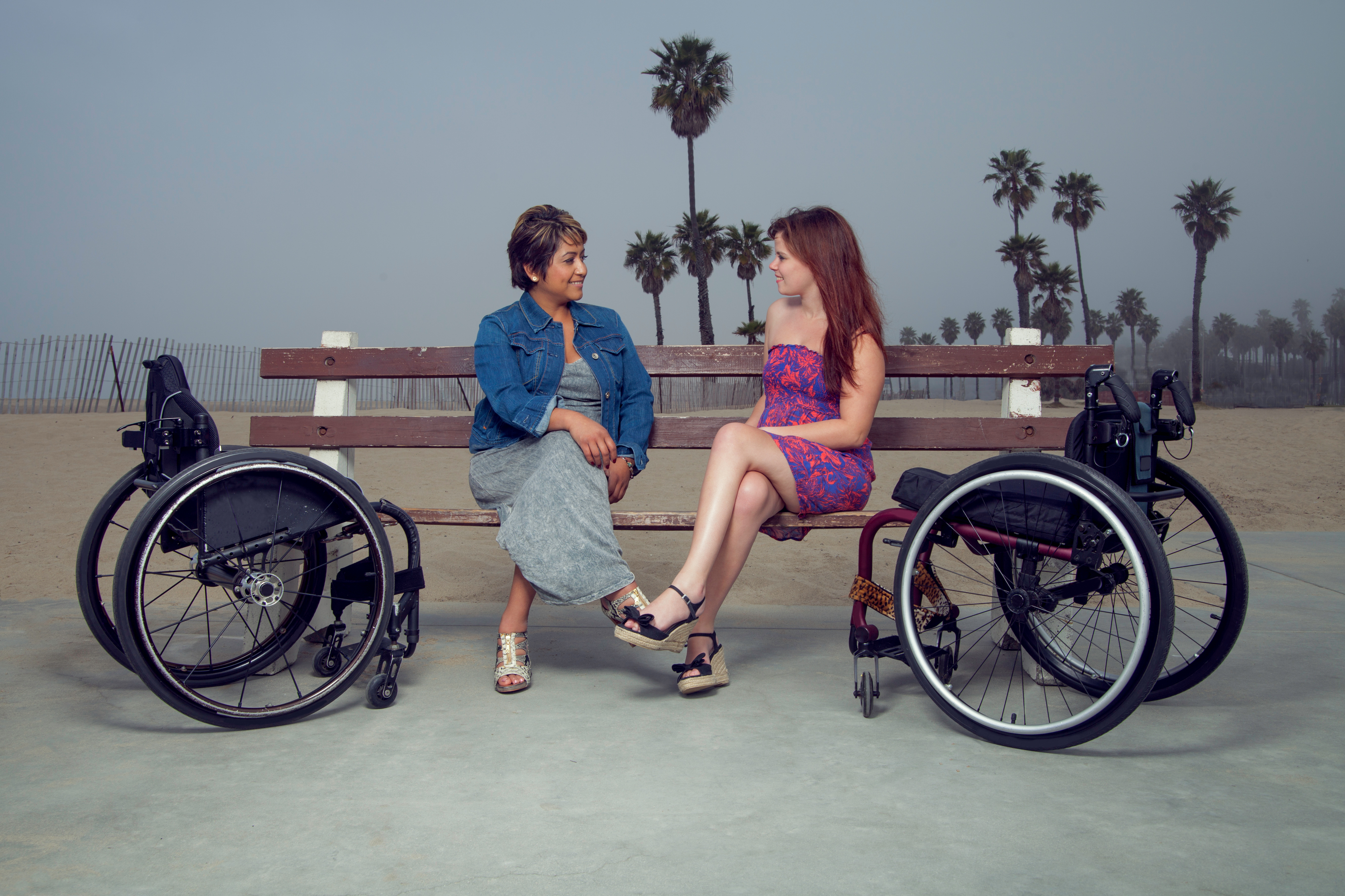 two women on bench next to wheelchairs
